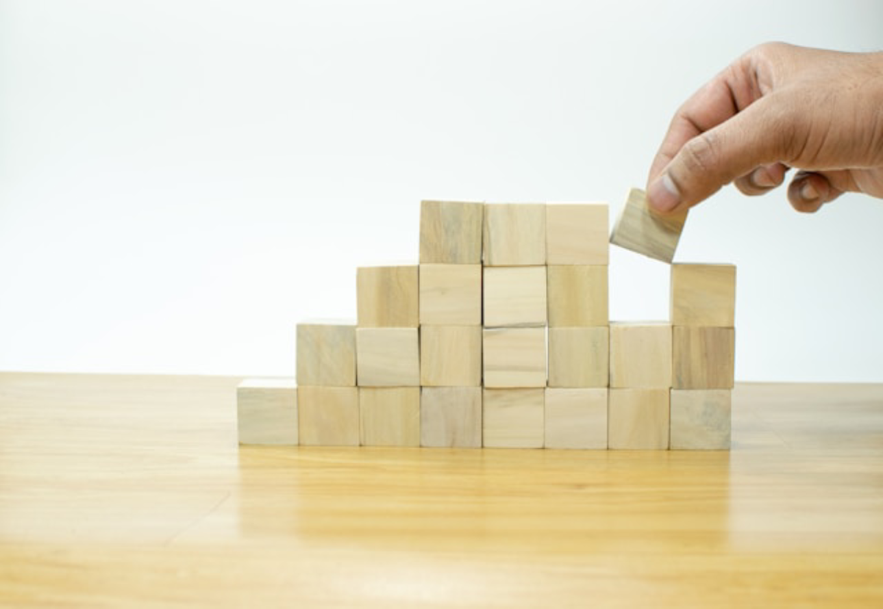 hand stacking wooden building blocks