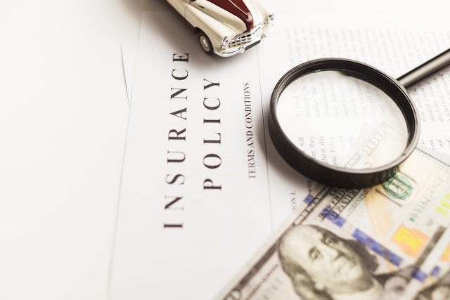 insurance policy, dollar bill, magnifying glass